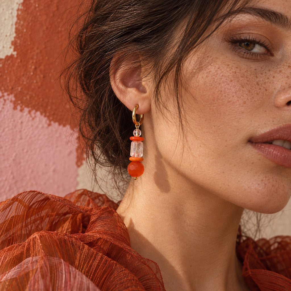 Model wearing LULA Ember orange and clear glass earrings